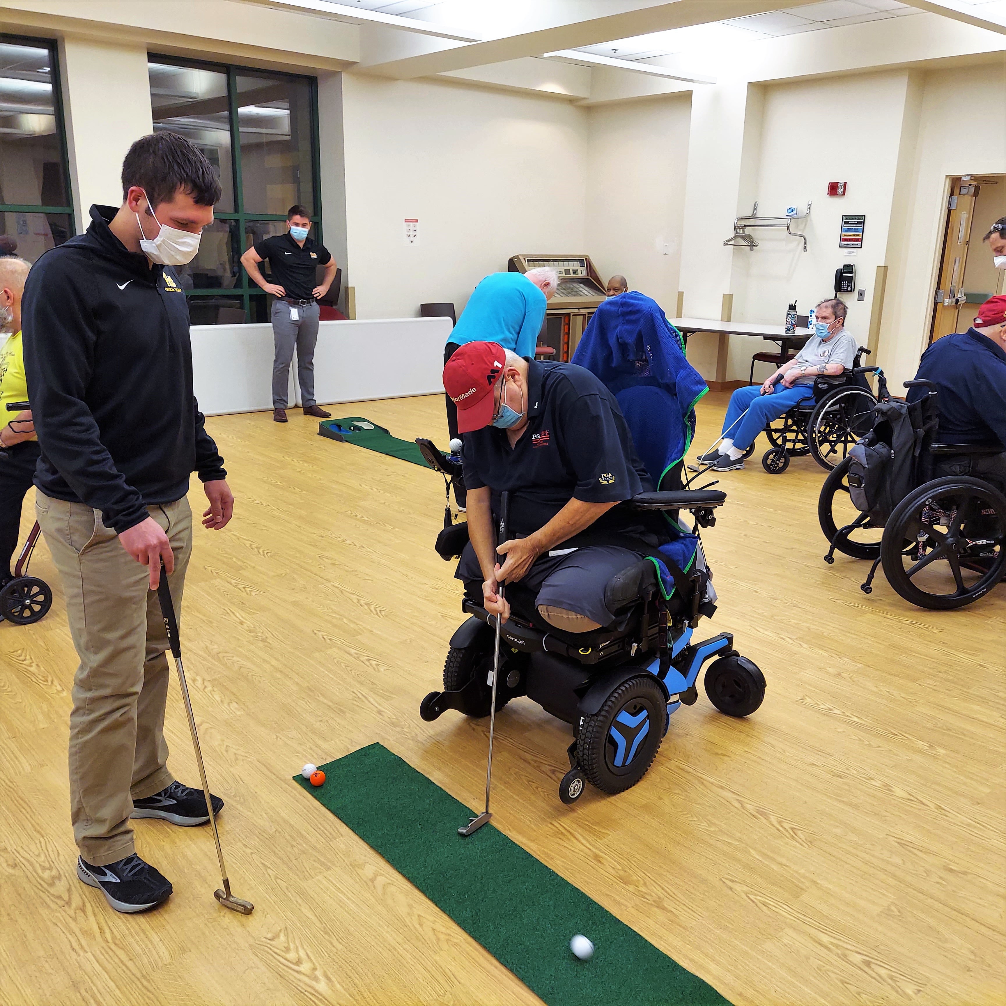 DPT student helping a veteran use adaptive golfing equipment